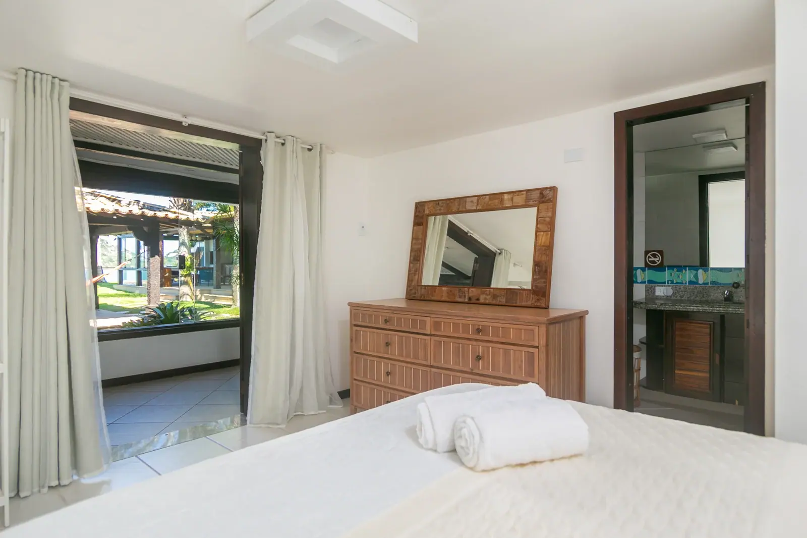 Quarto com cômoda de madeira · janela