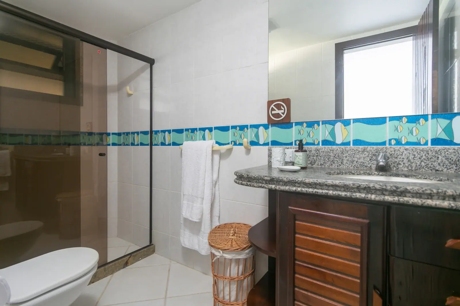 Quarto com cômoda de madeira · banheiro